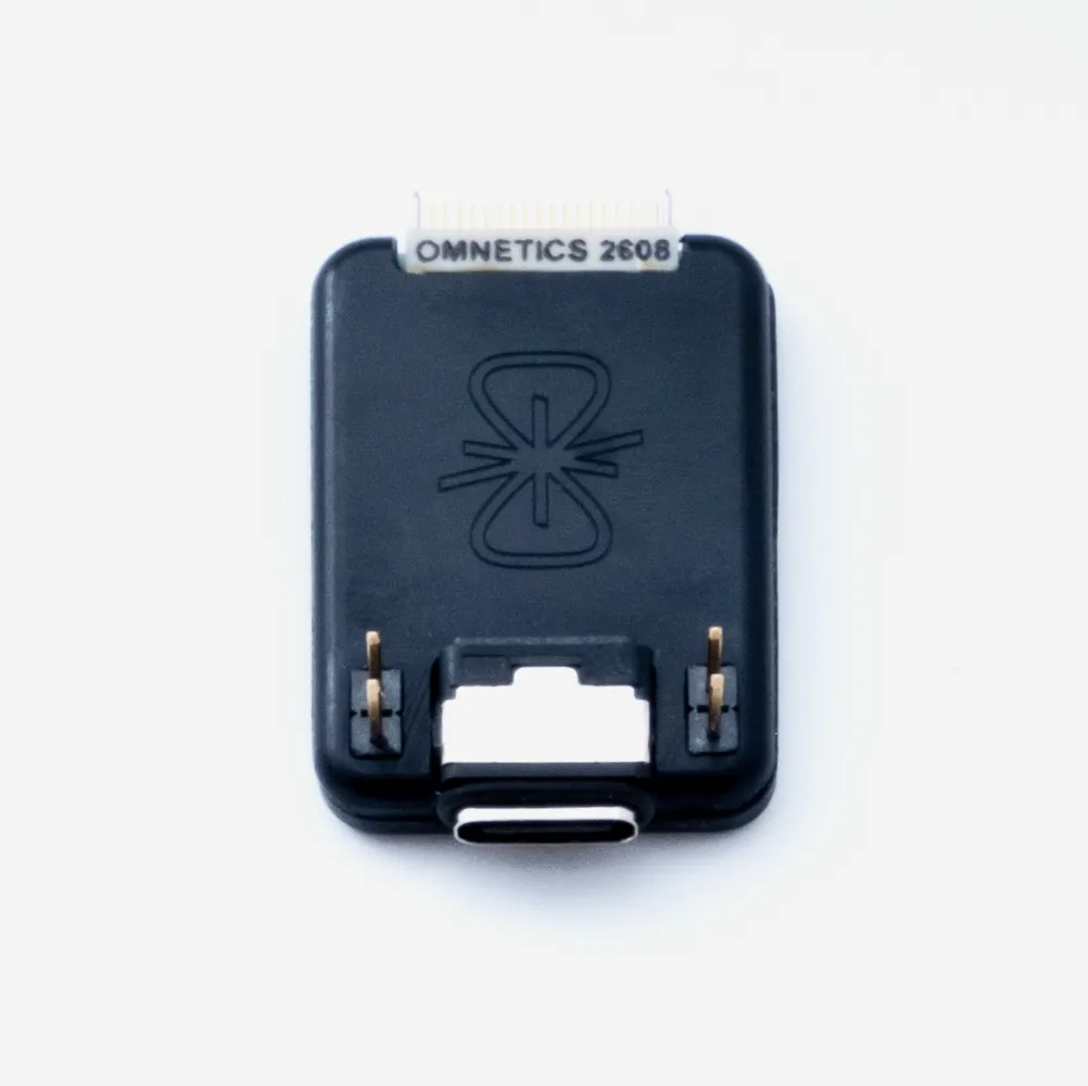 Photograph of small cube-shaped adapter with a USB-C port with a round, ridged base. There is an LED on the right side of the top of the adapter that is not lit.