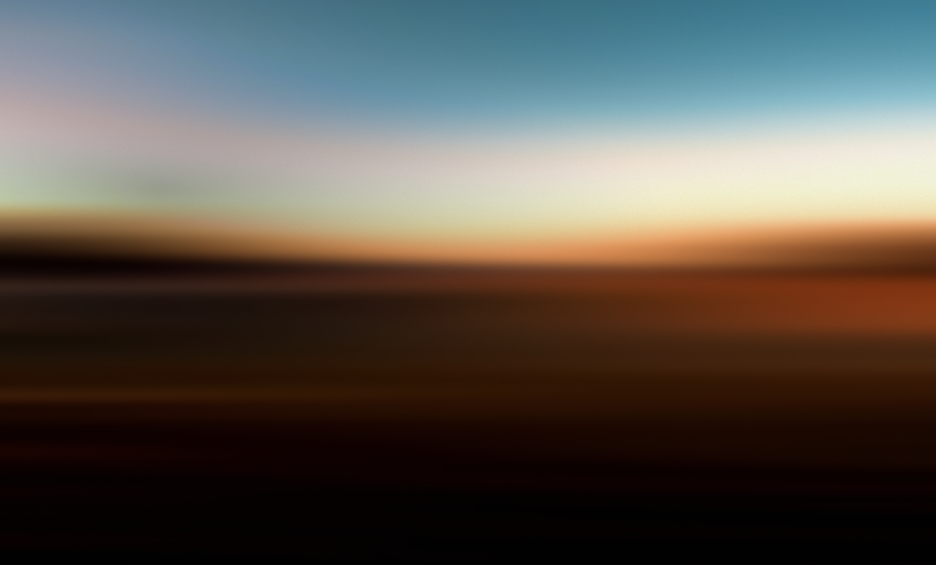 Image of a landscape with a hill. The sun is just starting lighten the horizon, but isn't quite up yet.