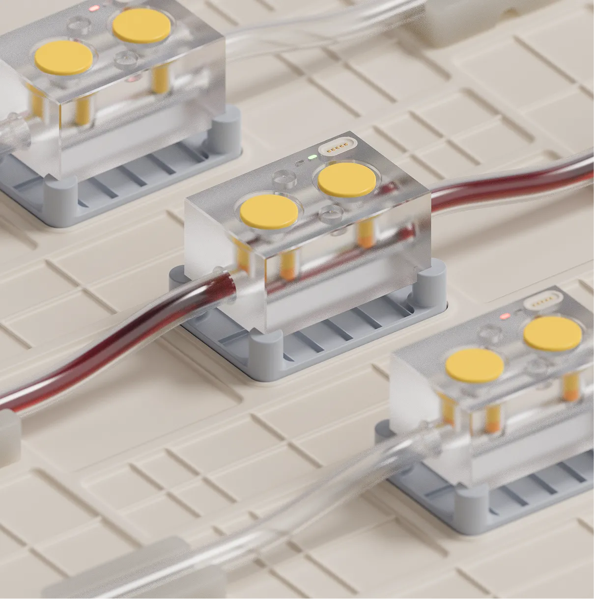 A close-up of tubes flowing with blood passing through transparent, rectangular sensors with yellow buttons.