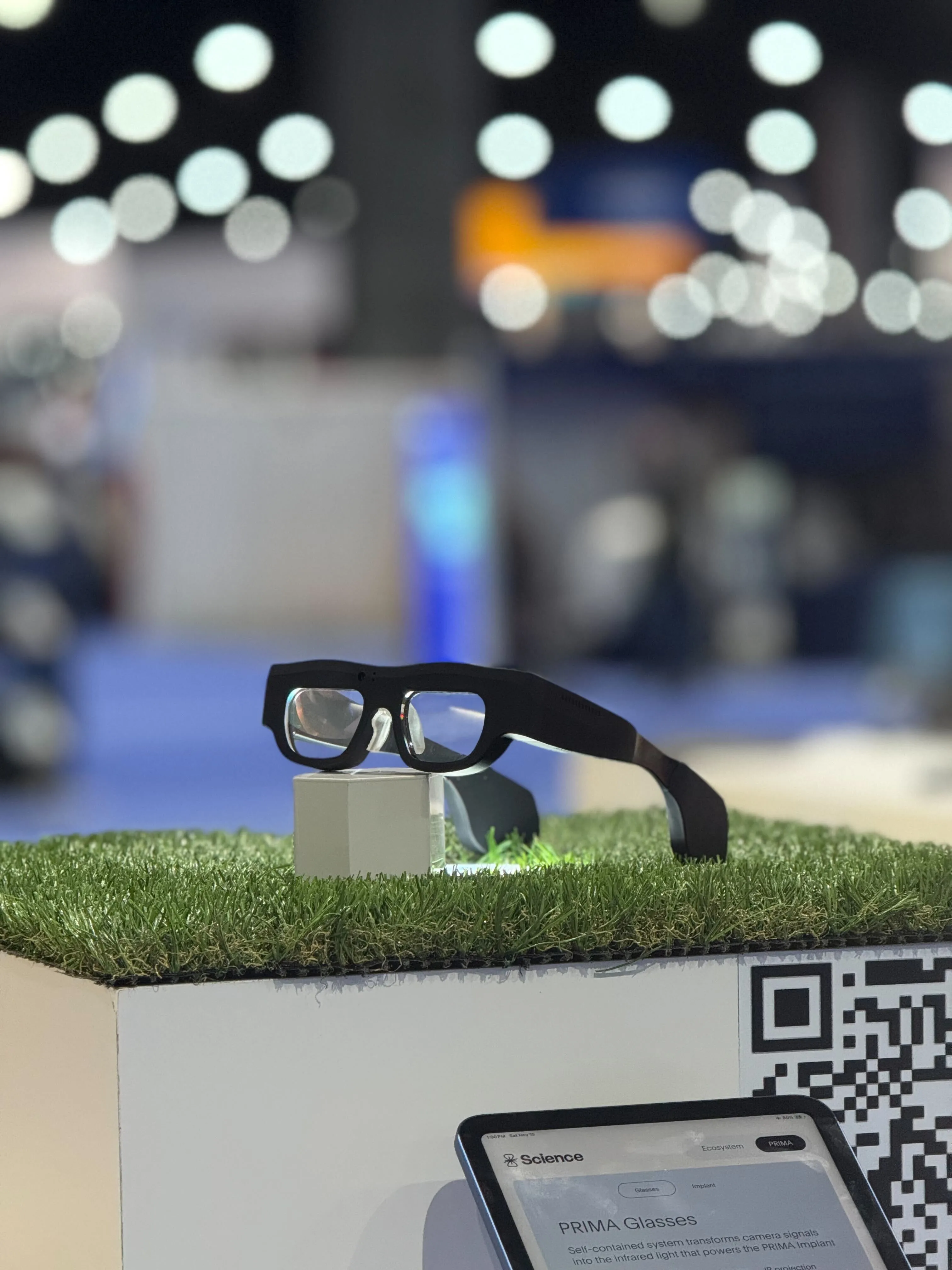 "Next-generation PRIMA glasses resting on a display plinth"