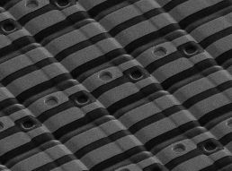 Scanning electron microscope photo of patterned vias in the dimpled surface of a thin film electrode.